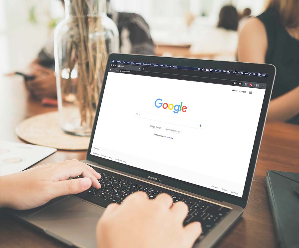 google search engine web page open on laptop sitting on desk