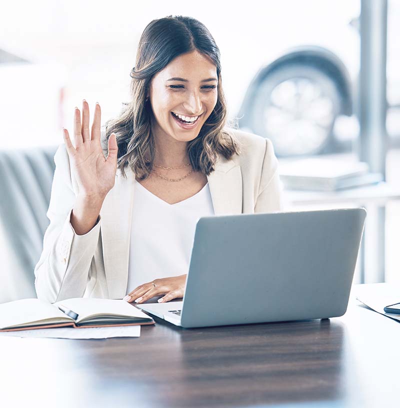 female attorney sitting on desk with laptop in front of her