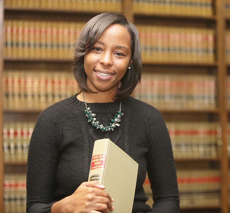 female attorney standing in law firm library with legal books in the background