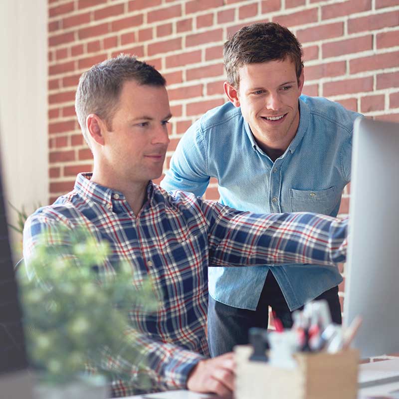 two hvac seo professionals working on computer