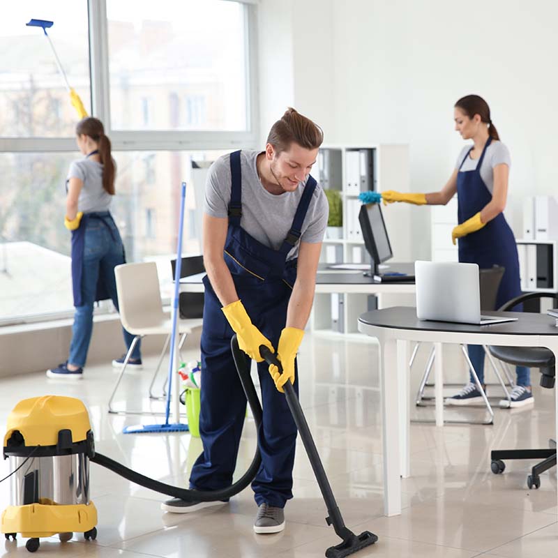 Team of janitors cleaning office