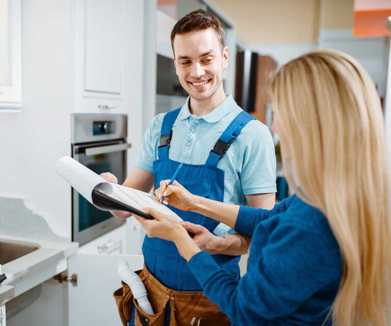 Male plumber and female customer in the kitchen